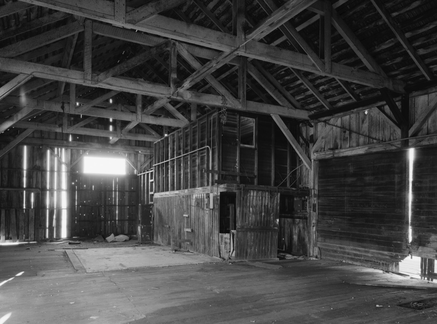 An empty timber freight warehouse with a small office built inside it